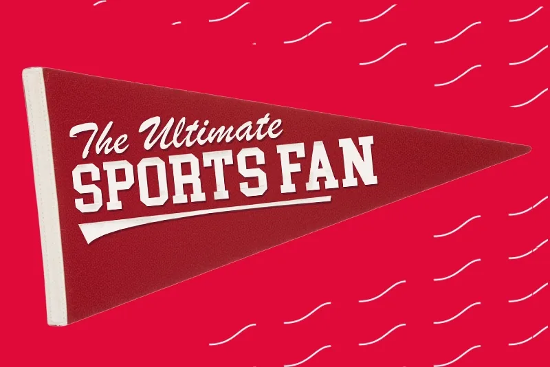 red felt sports pennant featuring the text "The Ultimate Sports Fan" in white lettering against a red background with white wave patterns.